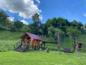 a wooden playground with a slide and a swing at Шепіт річки in Synevyr