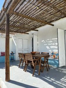 a dining room with a wooden table and chairs at Papoila in Grândola