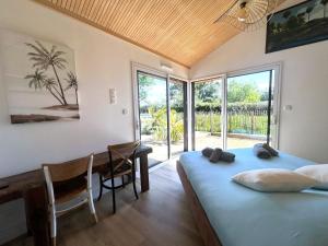 a bedroom with a bed and a desk and windows at Villa et Spa in Pornic +72 photos