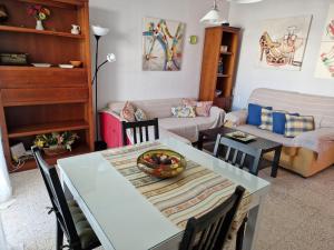 a living room with a table and a couch at Tranquilo y céntrico en Chipiona in Chipiona