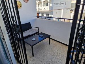 a couch sitting on a balcony with a table at Tranquilo y céntrico en Chipiona in Chipiona