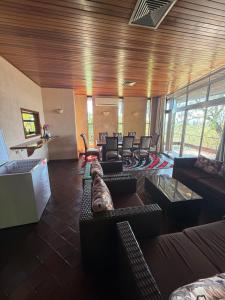 a large living room with couches and tables and chairs at Sunrise and sunsets lodge previously known as leopard lodge in Kariba