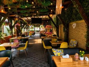 a restaurant with tables and chairs and a room with plants at Pensiunea Passion in Bucharest