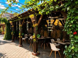 a restaurant with tables and chairs under a pergola at Pensiunea Passion in Bucharest