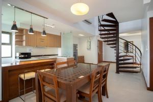 a kitchen with a table and chairs and a spiral staircase at Lasalle Suites Hotel & Residence in Bangkok