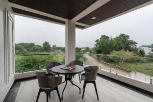 a porch with a table and chairs and a large window at Sunset view Villa 966o9o1oo6 Luxury 5BHK Villa with pool in Nathdwara 2km from temple only By SK in Nāthdwāra