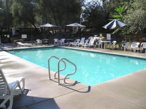 a swimming pool with chairs and tables and umbrellas at Ponderosa Camping Resort One-Bedroom Cabin 2 in Lotus