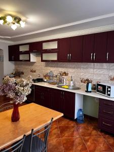 a kitchen with brown cabinets and a wooden table at Котедж "Під Крилом" in Dilyatyn +51 photos