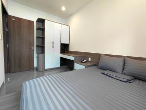 a bedroom with a large bed and a desk at ZENITH STAY by Lan's in Danang