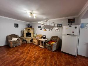 a living room with a white refrigerator and chairs at Котедж "Під Крилом" in Dilyatyn