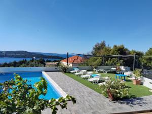 a villa with a swimming pool and lounge chairs at Villa Confido - Luxury 3BR Apartment with Private Pool near Trogir in Donji Seget