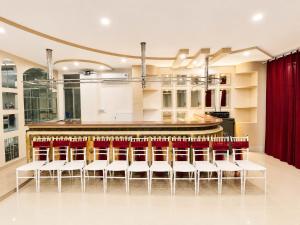 a bar with white chairs and a counter at Khách Sạn Mỹ Kim in Cà Mau