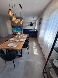 a dining room with a long wooden table and chairs at Villa Rosa - Luxury Apartments in Vrsi