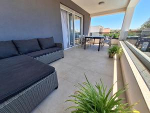 a living room with a couch and a table on a balcony at Villa Rosa - Luxury Apartments in Vrsi
