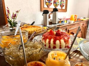 a table with a cake with strawberries on top of it at Pouso das Flores - Próximo a Maria Fumaça in Tiradentes +96 photos