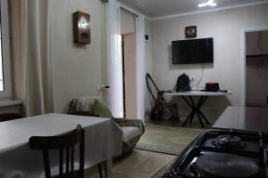 a kitchen and living room with a table and a stove at Sarytam in Bosteri