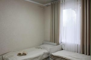 a room with a bed and a window with two hats on it at Sarytam in Bosteri