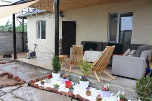 a patio with a couch and chairs and potted plants at Sarytam in Bosteri