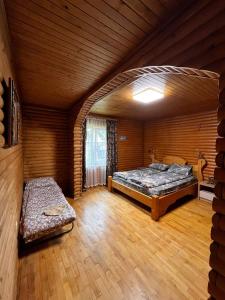a large room with two beds and a bench in it at Котедж "Під Крилом" in Dilyatyn