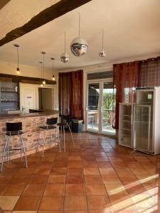 a kitchen with a tile floor with chairs and appliances at Domaine privatif 32c avec très grande Salle - Escale de La Jurade in Rogues