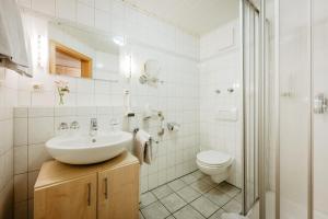 a white bathroom with a sink and a toilet at Hotel am Haidel in Hinterschmiding +32 photos