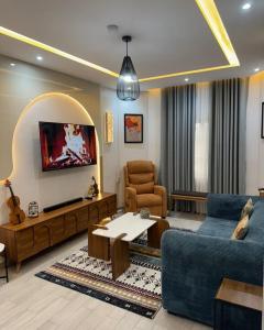 a living room with a blue couch and a table at Havenstay in Yaoundé