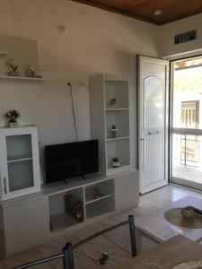 a living room with a flat screen tv on a wall at Lemon tree apartment in Kyllini