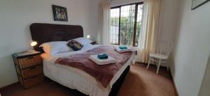 a bedroom with a bed with a table and a window at The Owls Nest in Lakeside +18 photos