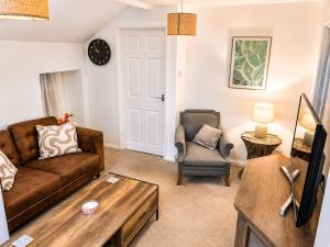 a living room with a couch and a chair at Cartref in Caerphilly
