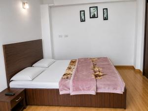 a bedroom with a bed with a blanket on it at Hotel Bharmour View in Brāhmaur