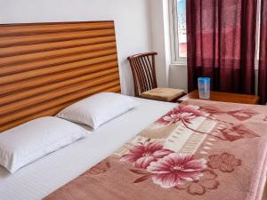 a bed with white pillows and a wooden head board at Hotel Bharmour View in Brāhmaur