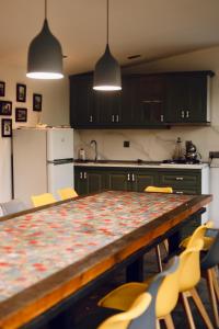 a kitchen with a table with chairs and a refrigerator at Villa Verde w Warm Pool, BBQ, Concierge in Baku