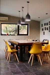 a dining room with a wooden table and yellow chairs at Villa Verde w Warm Pool, BBQ, Concierge in Baku
