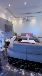 ein Wohnzimmer mit Sofa und Fernseher in der Unterkunft Palace M&E in Douala