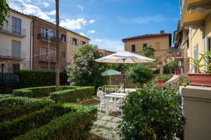 a patio with an umbrella and a table and chairs at Casa di Alfredo Affittacamere in Siena