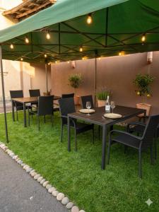 a patio with tables and chairs under a green umbrella at BS Brother in Ruse