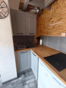 a kitchen with white cabinets and a wooden counter top at Le Nid de Formiguères in Formiguères