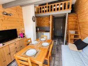 a dining room with a table and a bunk bed at Le Nid de Formiguères in Formiguères