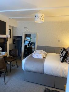 a bedroom with two beds and a table and a mirror at Cobweb Cottage in Patrington