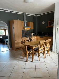 a kitchen with a wooden table and wooden chairs at Eva Domizil in Laudesfeld