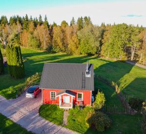 an aerial view of a red house with a car at Farm Stay Between Forests and Meadows in Ulricehamn