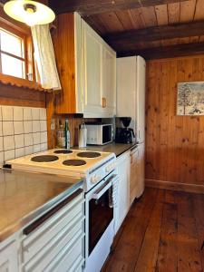 a kitchen with white cabinets and a stove top oven at Farm Stay Between Forests and Meadows in Ulricehamn