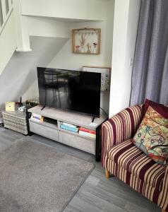 a living room with a couch and a flat screen tv at The Hideaway-Sharples-Bolton in Bolton
