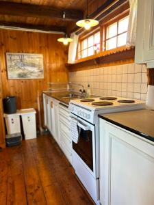 a kitchen with a white stove and a sink at Farm Stay Between Forests and Meadows in Ulricehamn +27 photos