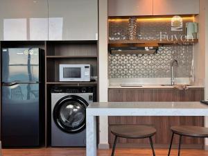 a kitchen with a washing machine and a microwave at Nook Inn - Apec Phu Yen in Tuy Hoa