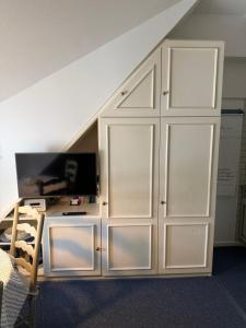 a large white cabinet with a flat screen tv at Friesenhof Süderende Apt.4 in Westerland