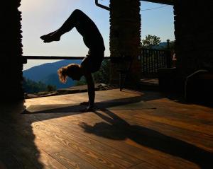 a woman doing a yoga pose on a wooden floor at Stone Oven House in Rorá +60 photos