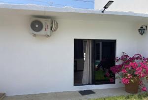 ein weißes Haus mit einem Fenster und einem Ventilator in der Unterkunft CasaPalmitas in Las Varas