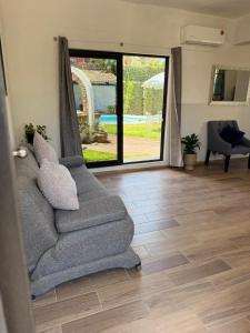 ein Wohnzimmer mit Sofa und Glasschiebetür in der Unterkunft CasaPalmitas in Las Varas
