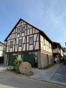a half timbered house with two green garage at Wohnen im Denkmal in Weilrod